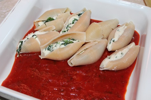 Arrange filled shells on a layer of sauce.