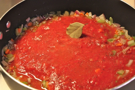 Add in crushed tomatoes, wine, and seasonings.